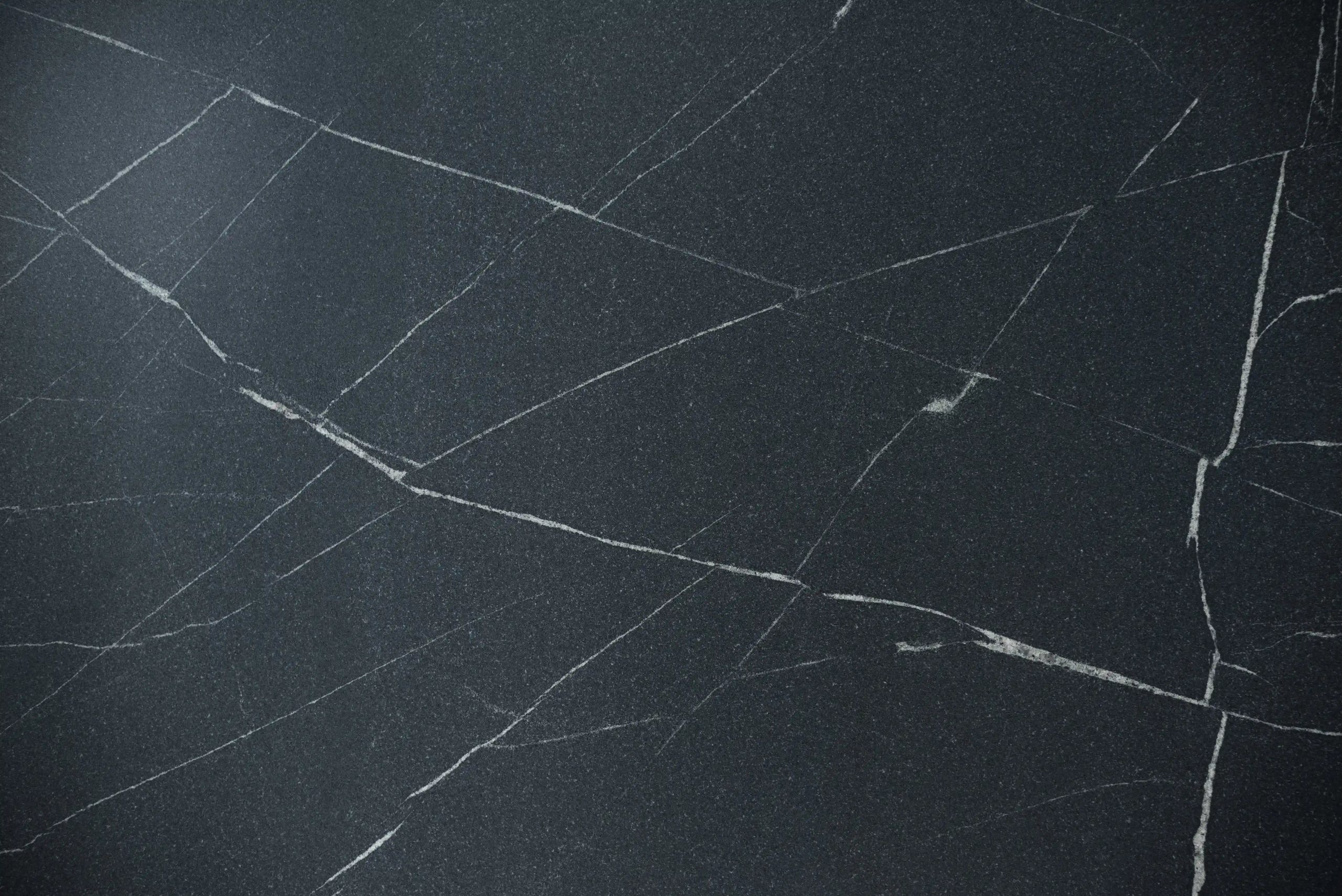 Chapa de granito Vincent Black de perto: fundo preto profundo cortado por veios brancos finos e retos que se cruzam